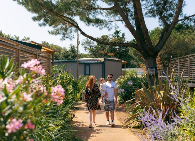 Balade d'une famille dans une allée fleurie du camping 